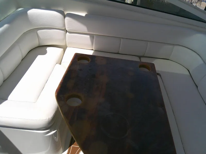 Slide: The Image of Interior seating area of 2009 Everglades 350LX boat with white cushions and wooden table. - 18