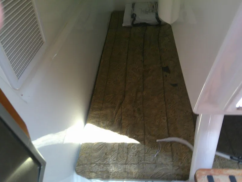 Slide: The Image of 2009 Everglades 350LX cabin interior with a narrow bed and patterned mattress. - 22