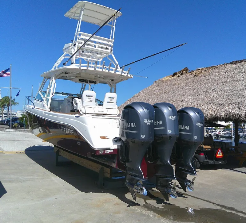 Slide: The Image of 2009 Everglades 350LX boat with triple Yamaha 350 engines, docked under clear blue sky. - 6