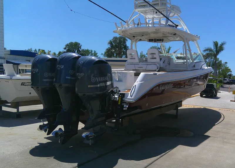 Slide: The Image of 2009 Everglades 350LX boat with triple Yamaha engines, docked outdoors. - 8