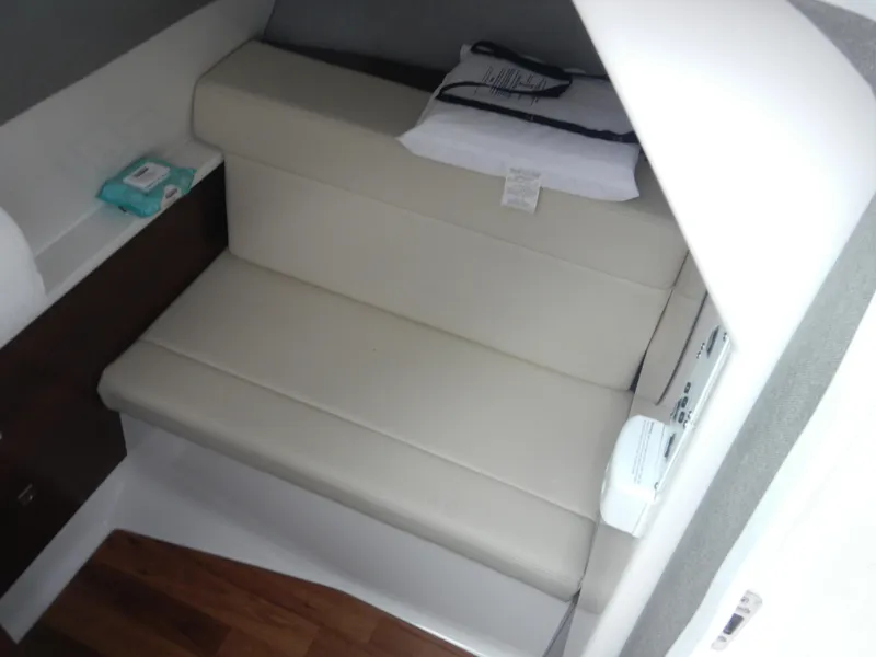 Slide: The Image of 2022 Chaparral 280 OSX interior cabin with beige seating and wooden flooring. - 17