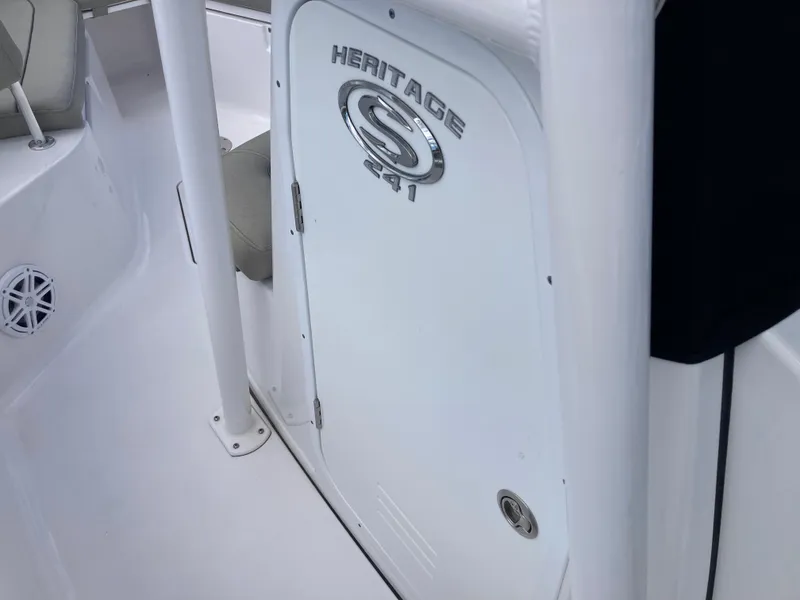 Slide: The Image of 2022 Sportsman 241 Heritage boat interior, featuring a sleek white design and branded door. - 15