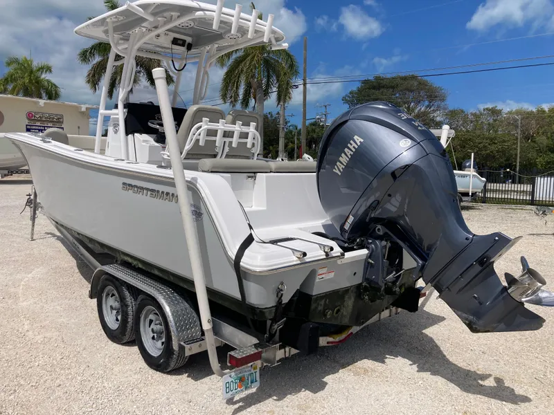 Slide: The Image of 2022 Sportsman 241 Heritage boat with Yamaha engine on trailer, parked outdoors. - 4