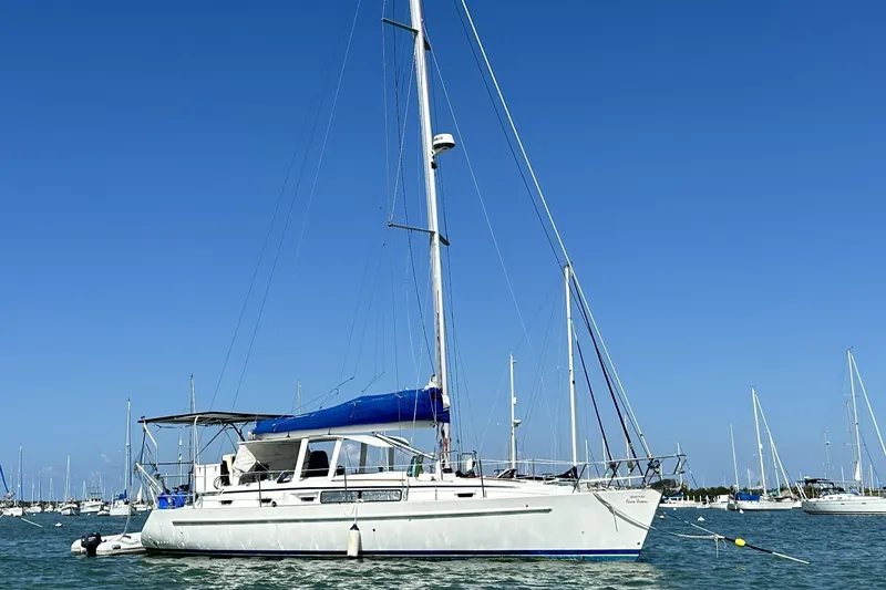 Slide: The Image of 1999 Beneteau Oceanis 40CC sailboat anchored in calm waters under clear blue sky. - 0