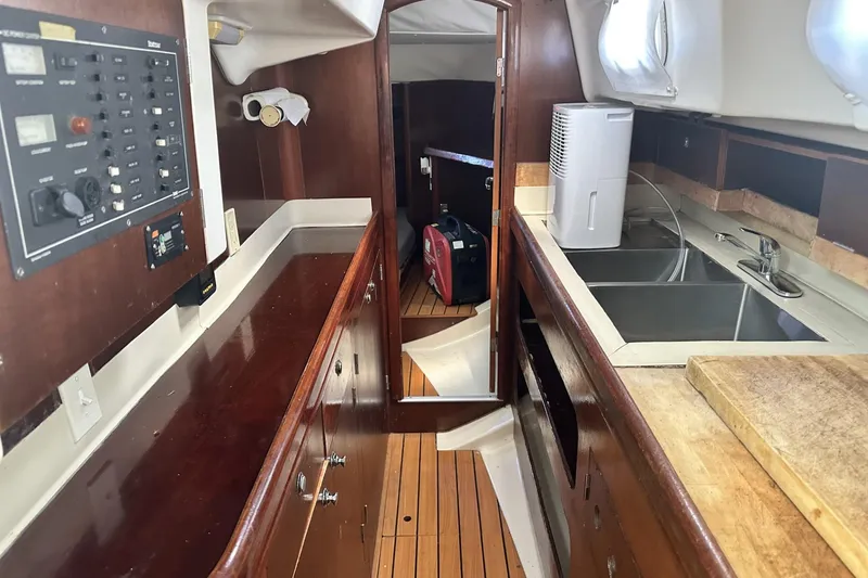 Slide: The Image of Interior of 1999 Beneteau Oceanis 400 yacht with wooden cabinetry and dual sinks. - 11
