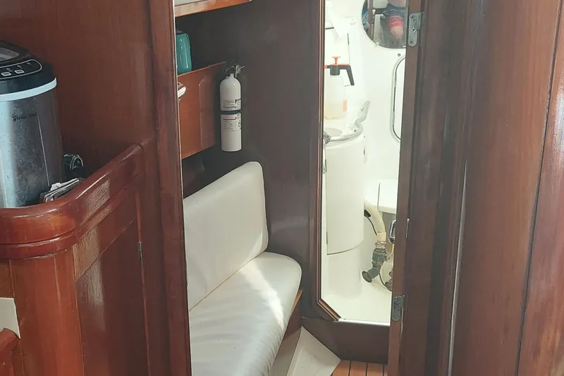 Slide: The Image of Interior of 1999 Beneteau Oceanis 40CC yacht, featuring wooden cabinetry and seating. - 15