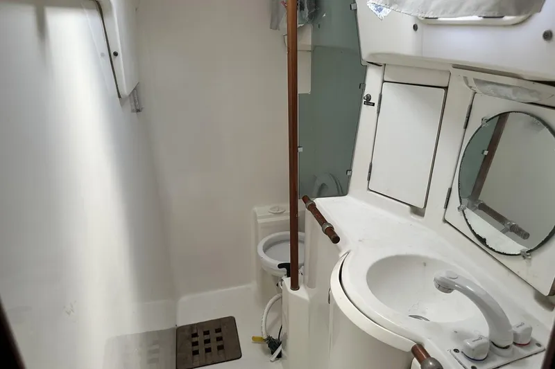 Slide: The Image of Bathroom interior of 1999 Beneteau Oceanis 400 yacht, featuring sink, mirror, and toilet. - 18