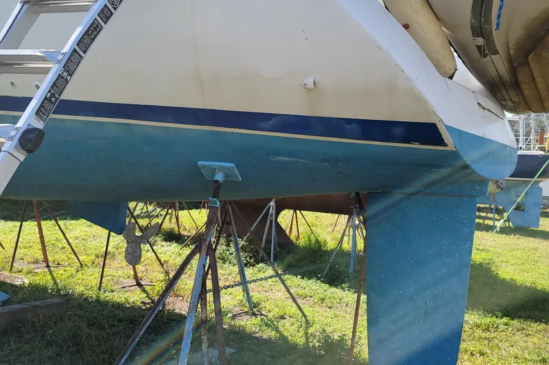 Slide: The Image of Beneteau Oceanis 40CC 1999 sailboat on stands, showing hull and keel in a grassy area. - 28