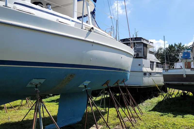 Slide: The Image of 1999 Beneteau Oceanis 40CC sailboat on stands, surrounded by other boats, under clear sky. - 30