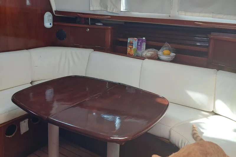 Slide: The Image of Interior of 1999 Beneteau Oceanis 400 yacht with wooden table and white seating. - 8