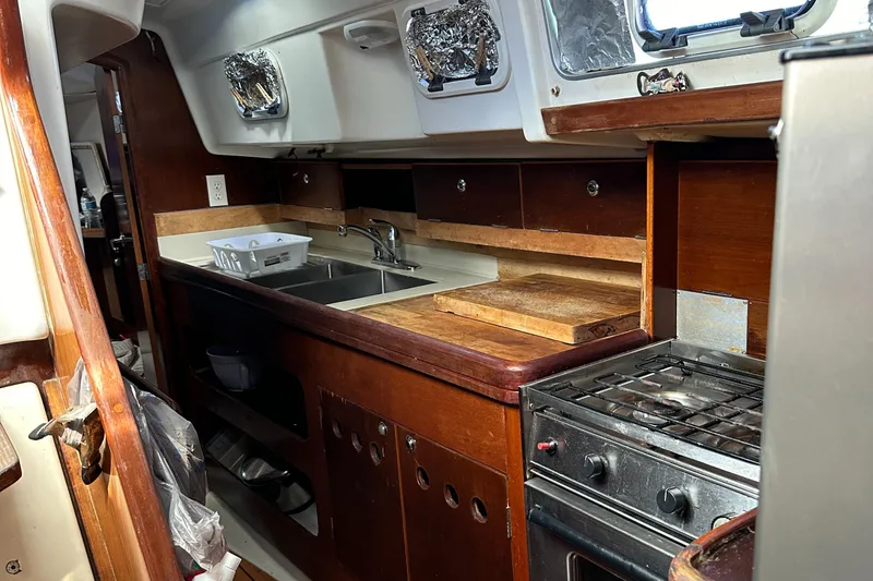 Slide: The Image of Interior of 1999 Beneteau Oceanis 40CC yacht kitchen with stove, sink, and wooden cabinetry. - 9