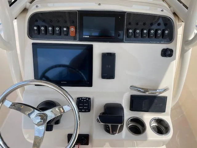 Slide: The Image of 2022 Grady-White Fisherman 216 dashboard with steering wheel and electronic controls. - 12