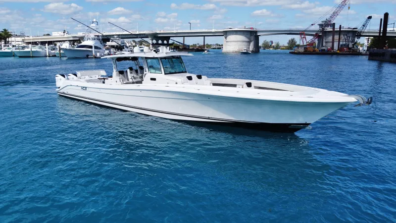 Slide: The Image of 2018 HCB 53 Sueños boat on blue water near a bridge and marina. - 0