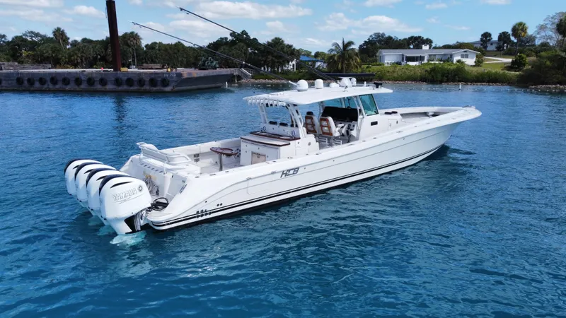 Slide: The Image of 2018 HCB 53 Sueños boat on clear blue water, featuring multiple outboard engines. - 11
