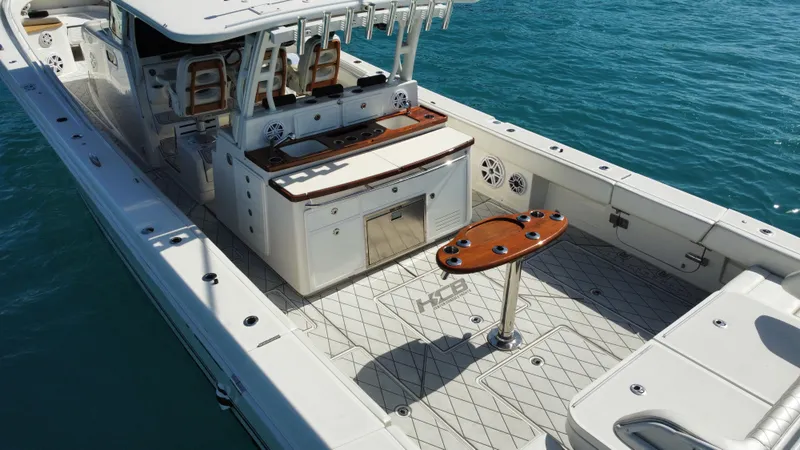 Slide: The Image of 2018 HCB 53 Sueños boat with spacious deck and luxurious seating on clear blue water. - 14