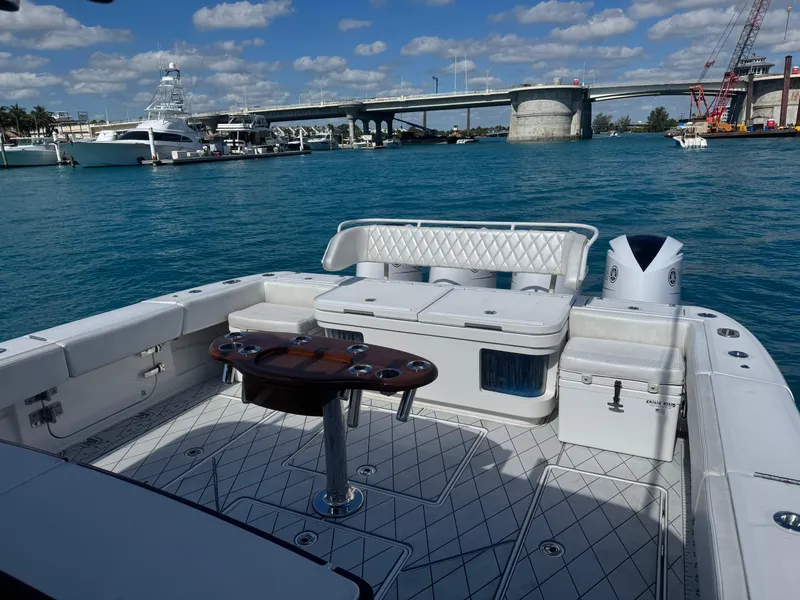 Slide: The Image of 2018 HCB 53 Sueños boat with luxurious seating, docked near a bridge under a blue sky. - 15