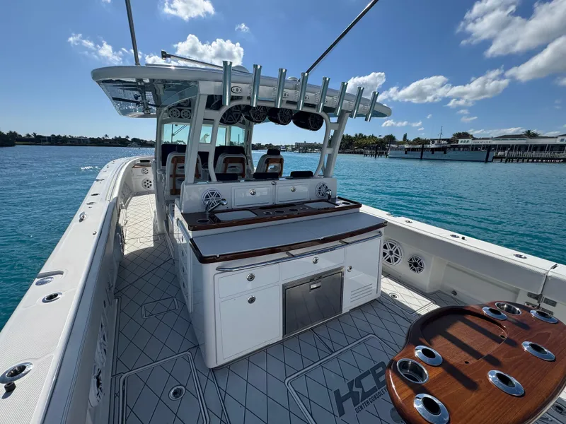 Slide: The Image of 2018 HCB 53 Sueños boat interior with seating and fishing rod holders on a sunny day. - 16