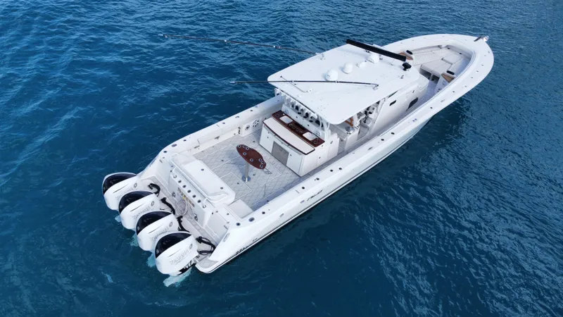 Slide: The Image of 2018 HCB 53 Sueños boat on blue ocean water, featuring multiple outboard engines. - 22