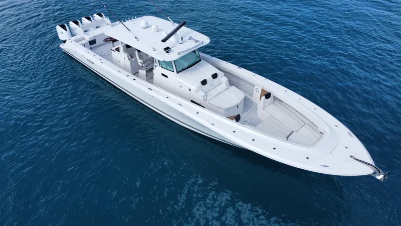 Slide: The Image of 2018 HCB 53 Sueños boat on open water, featuring sleek design and multiple engines. - 23