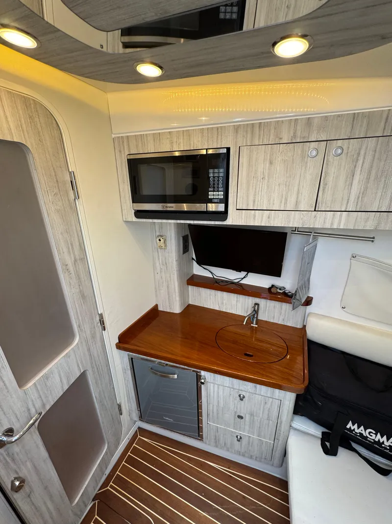 Slide: The Image of 2018 HCB 53 Sueños interior with kitchenette, microwave, and modern cabinetry. - 24