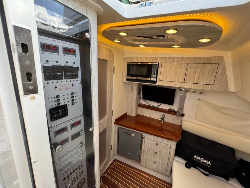 Slide: The Image of 2018 HCB 53 Sueños yacht interior with control panel, kitchenette, and seating area. - 25