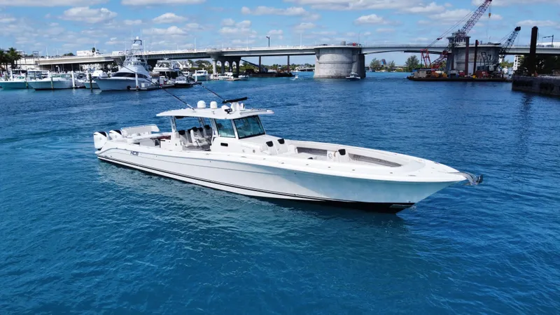 Slide: The Image of 2018 HCB 53 Sueños yacht cruising in a vibrant blue marina with a bridge in the background. - 5