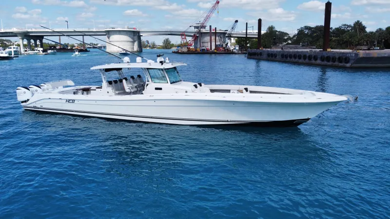 Slide: The Image of 2018 HCB 53 Sueños boat on blue water near a bridge and construction site. - 7