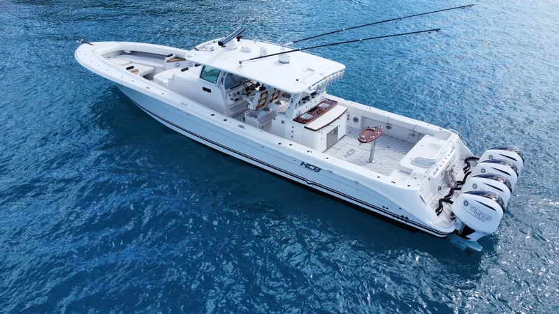 Slide: The Image of 2018 HCB 53 Sueños boat on clear blue water, featuring multiple outboard engines. - 9