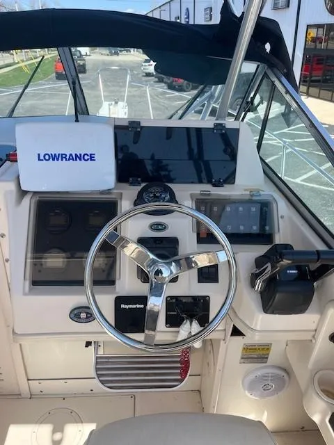 Slide: The Image of 2005 Grady-White 232 Gulfstream boat cockpit with steering wheel and navigation equipment. - 8