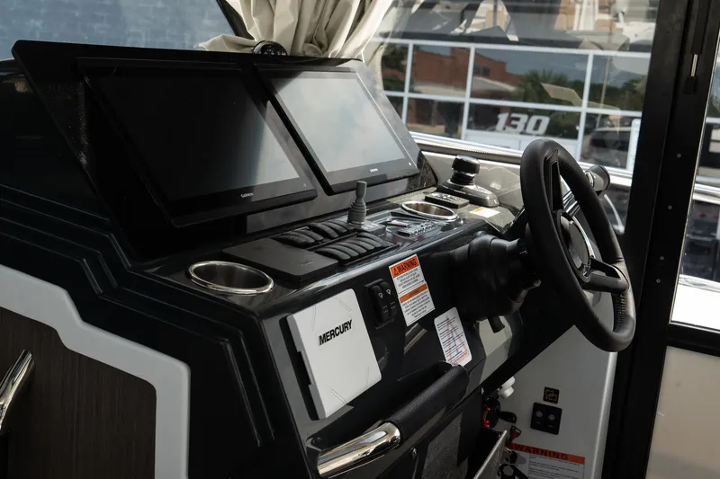 Slide: The Image of 2025 Wellcraft 38 Explorer helm with dual screens and Mercury controls. - 19