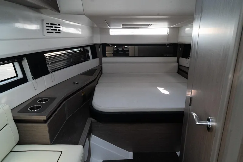 Slide: The Image of 2025 Wellcraft 38 Explorer cabin interior with bed, modern design, and natural light. - 23