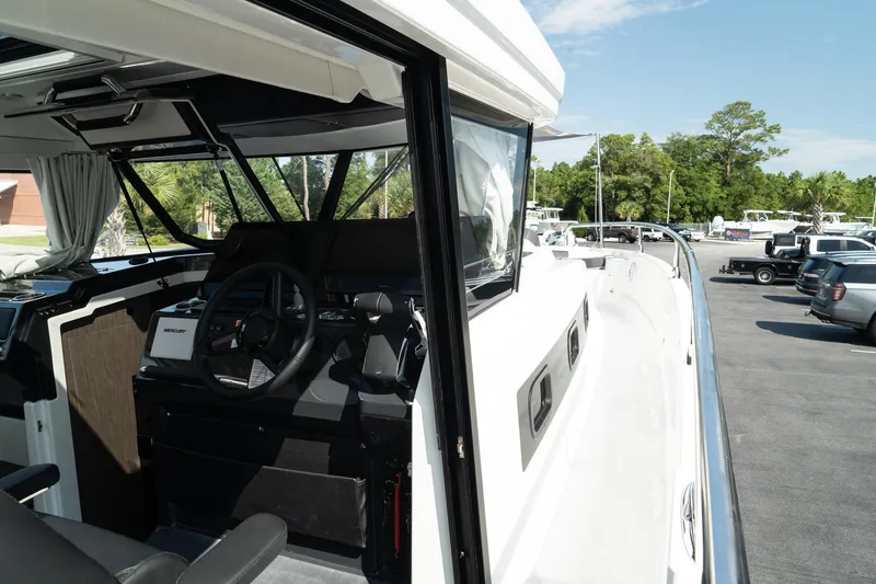 Slide: The Image of 2025 Wellcraft 38 Explorer boat cockpit with steering wheel, docked outdoors. - 36