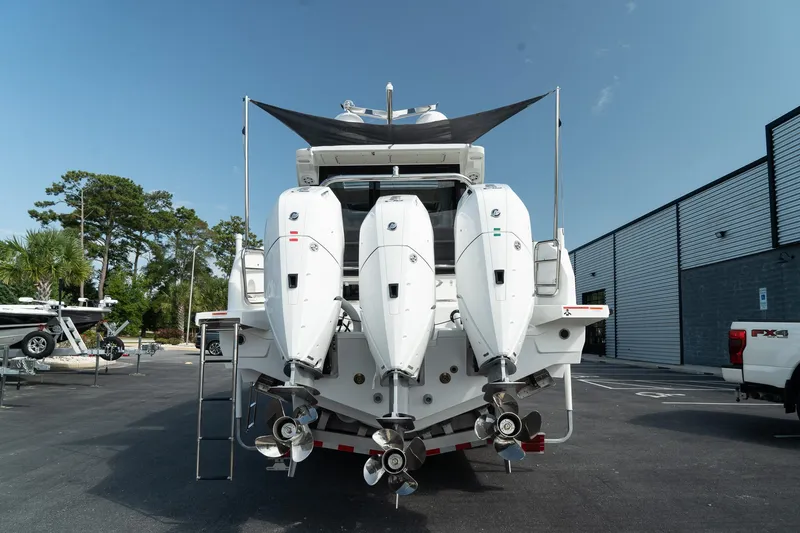 Slide: The Image of 2025 Wellcraft 38 Explorer boat with triple outboard engines, parked outdoors. - 4