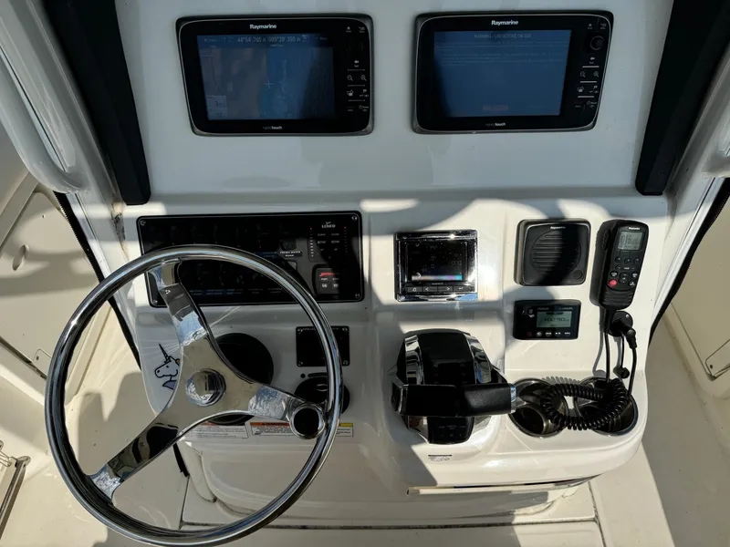Slide: The Image of Control panel of a 2015 Boston Whaler 250 Outrage boat with steering wheel and electronics. - 11