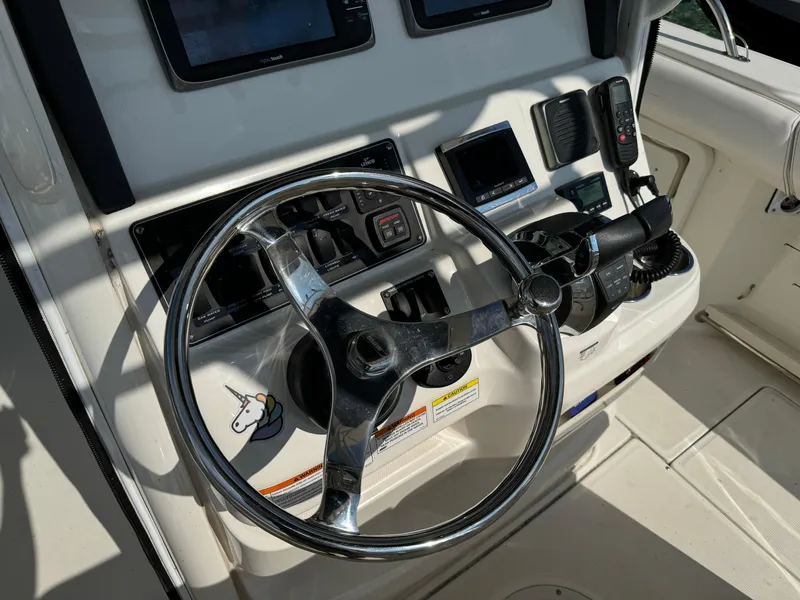 Slide: The Image of 2015 Boston Whaler 250 Outrage helm with steering wheel and control panel. - 13
