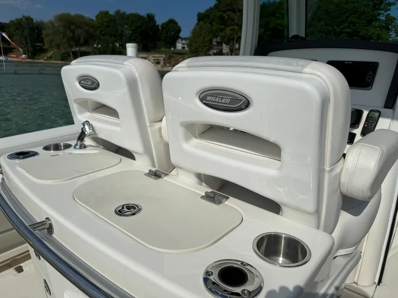 Slide: The Image of 2015 Boston Whaler 250 Outrage boat interior with seating and cup holders. - 17