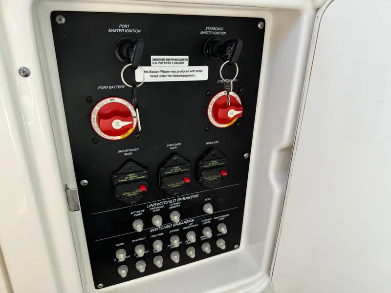 Slide: The Image of Control panel of a 2015 Boston Whaler 250 Outrage boat, featuring ignition and battery switches. - 27