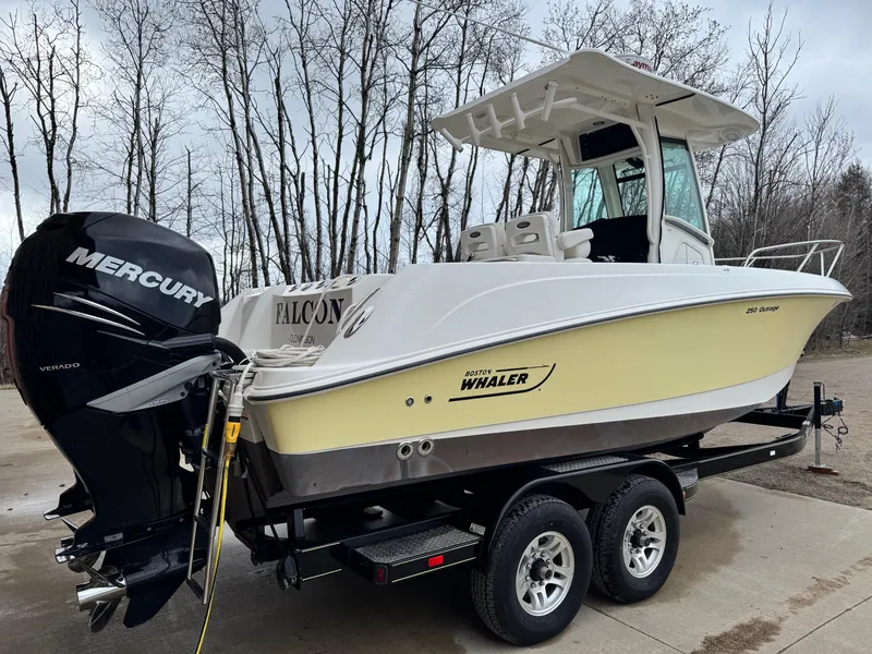 Slide: The Image of 2015 Boston Whaler 250 Outrage boat on trailer with Mercury engine, parked outdoors. - 3