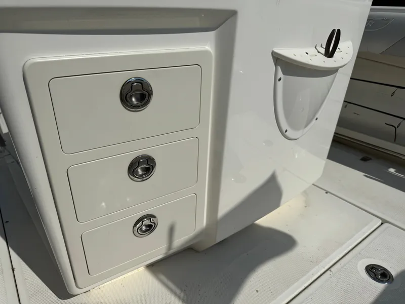 Slide: The Image of 2015 Boston Whaler 250 Outrage boat storage compartments and cup holder detail. - 33