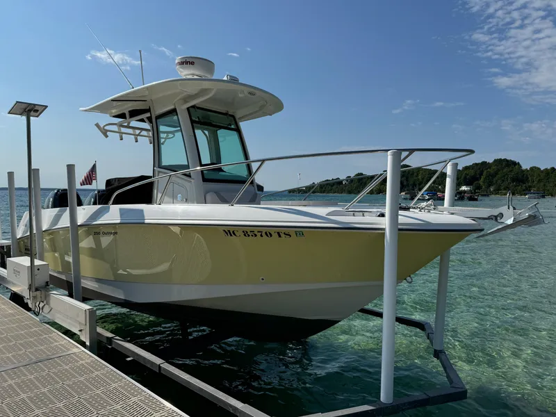 Slide: The Image of 2015 Boston Whaler 250 Outrage boat docked on clear water under blue sky. - 6