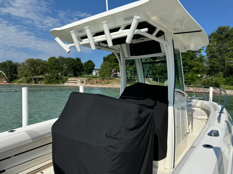 Slide: The Image of 2015 Boston Whaler 250 Outrage boat docked by a scenic shoreline. - 8