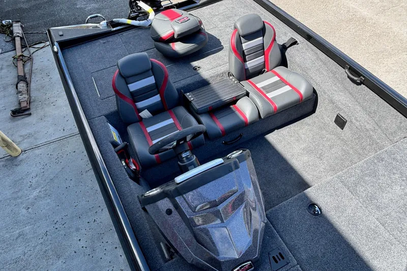 Slide: The Image of 2025 Ranger RT188 boat interior with gray and red seating, steering console, and carpeted flooring. - 12