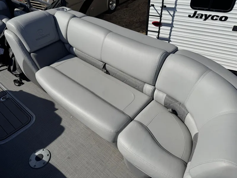 Slide: The Image of 2020 Regency 230 LE3 boat interior with beige cushioned seating and carpeted floor. - 16