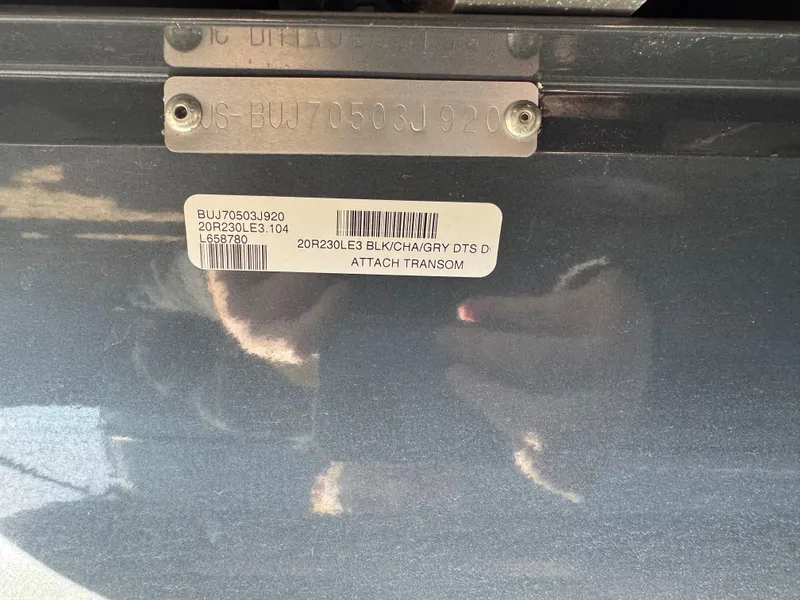 Slide: The Image of 2020 Regency 230 LE3 boat with ladder and Mercury engine in a garage setting. - 19