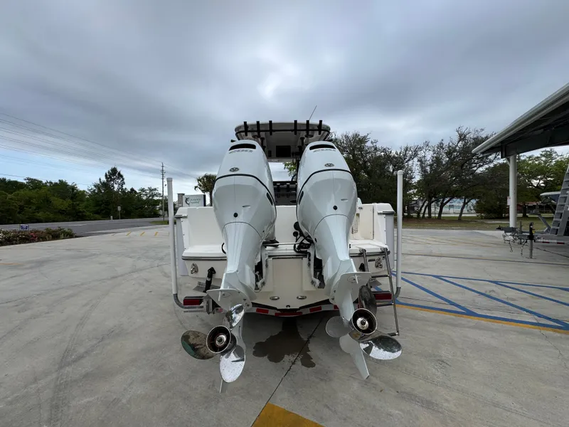 Slide: The Image of 2023 Sea Born LX26 Center Console with dual outboard motors, parked outdoors. - 15