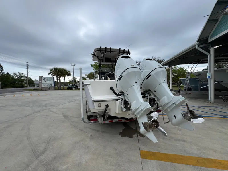 Slide: The Image of 2023 Sea Born LX26 Center Console boat with dual outboard motors in a parking area. - 16