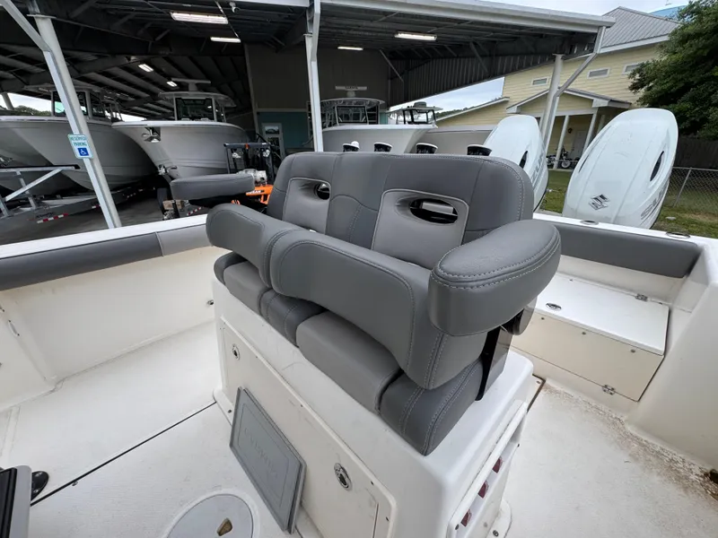 Slide: The Image of 2023 Sea Born LX26 Center Console boat with gray seating in a marina setting. - 25