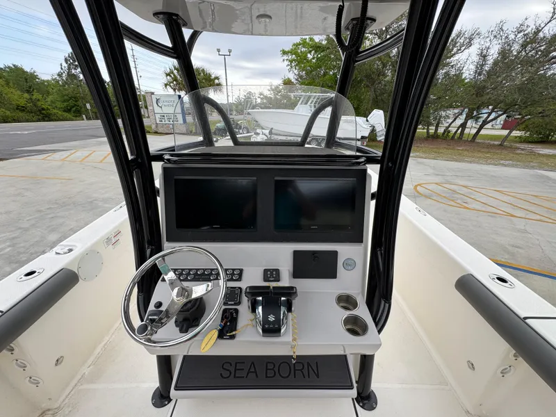 Slide: The Image of 2023 Sea Born LX26 Center Console boat dashboard with dual screens and steering wheel. - 28
