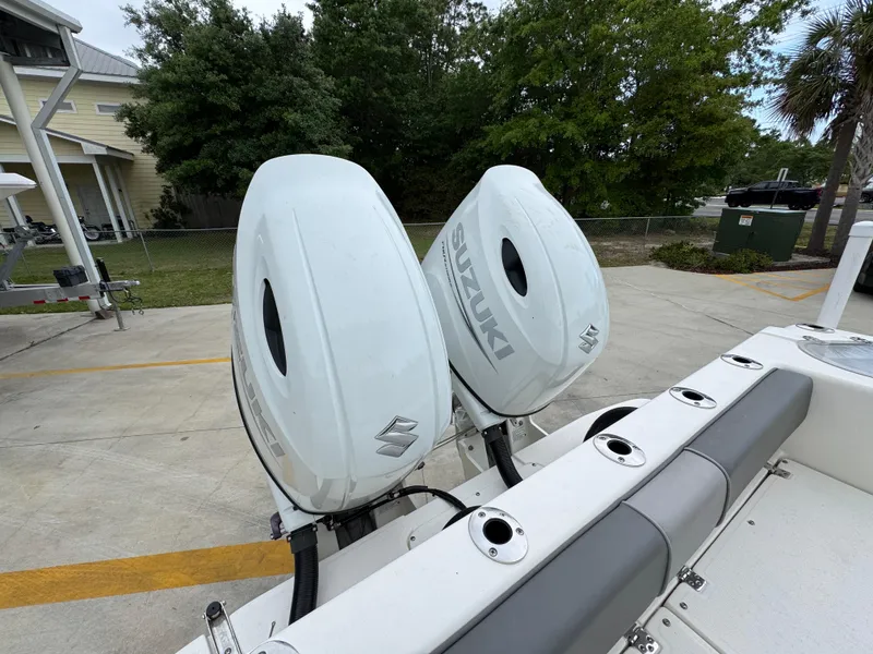 Slide: The Image of 2023 Sea Born LX26 Center Console with dual Suzuki outboard motors in a parking area. - 34