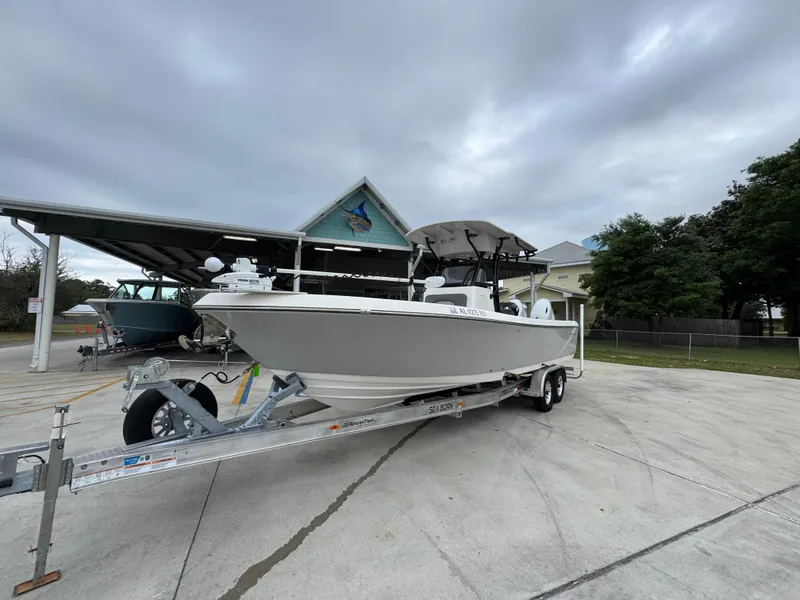 Slide: The Image of 2023 Sea Born LX26 Center Console boat on trailer, parked outdoors under cloudy sky. - 4